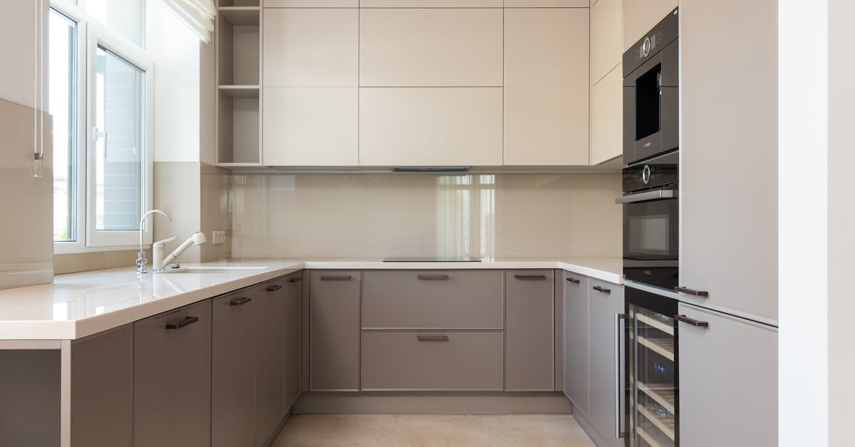Lysol on microwave, how to clean off? - Interior of bright modern kitchen with cupboards and oven with microwave near sink with tap next to window