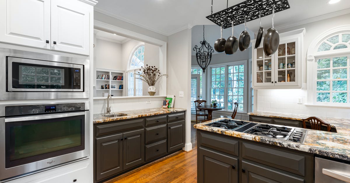 Maintaining drip pans on coil oven hobs - Pots and Pans Hanging Over a Stove on a Kitchen Counter