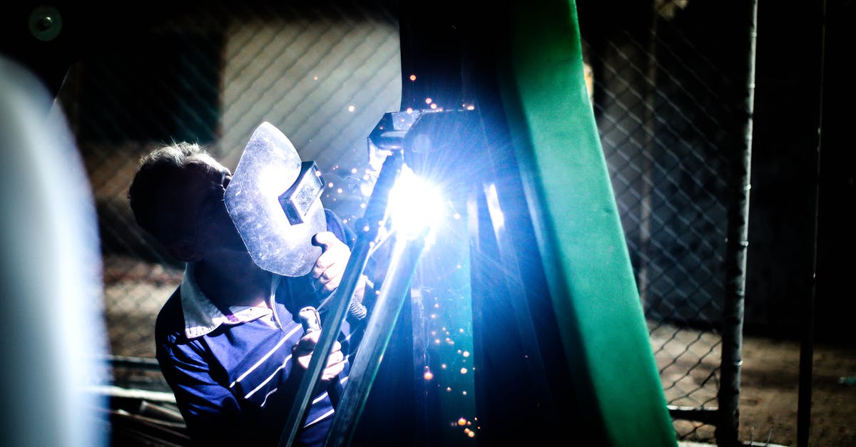 Maintenance and safety of cast iron skillet - Industry worker welding iron pieces at night