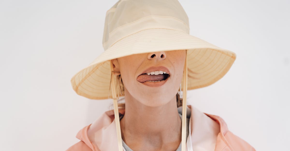 Make popcorn: Cover fully or not? - Stylish woman in hat with tongue out