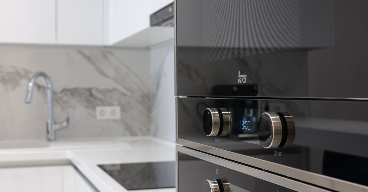 Making black bread in a microwave oven - Interior of contemporary kitchen with stainless white surface induction cooker and electronic stove in modern apartment
