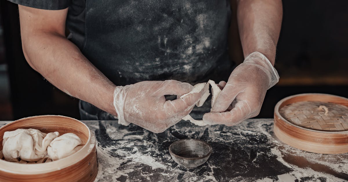 Making doughballs (dumplings) with strong brown flour and shredded suet - Person in Black Shirt Holding Dumpling Wrapper