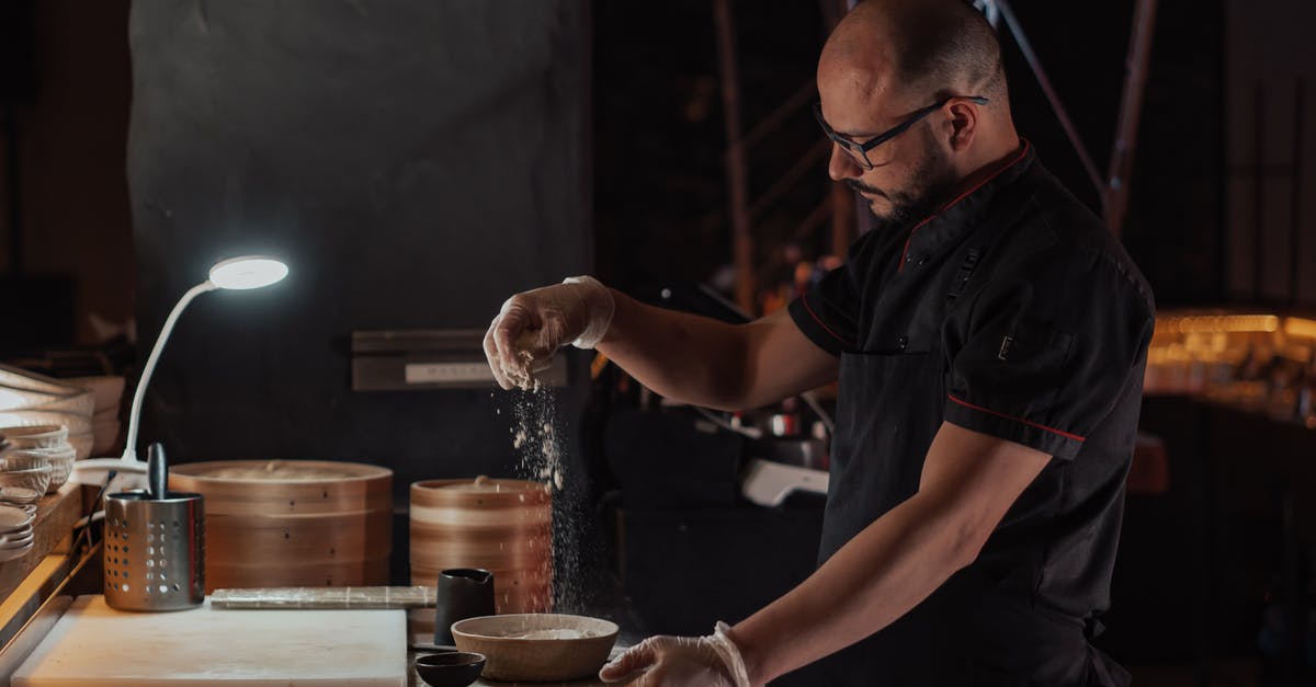 Making doughballs (dumplings) with strong brown flour and shredded suet - Man in Black Chef Uniform Sprinkling Flour on Ceramic Bowl