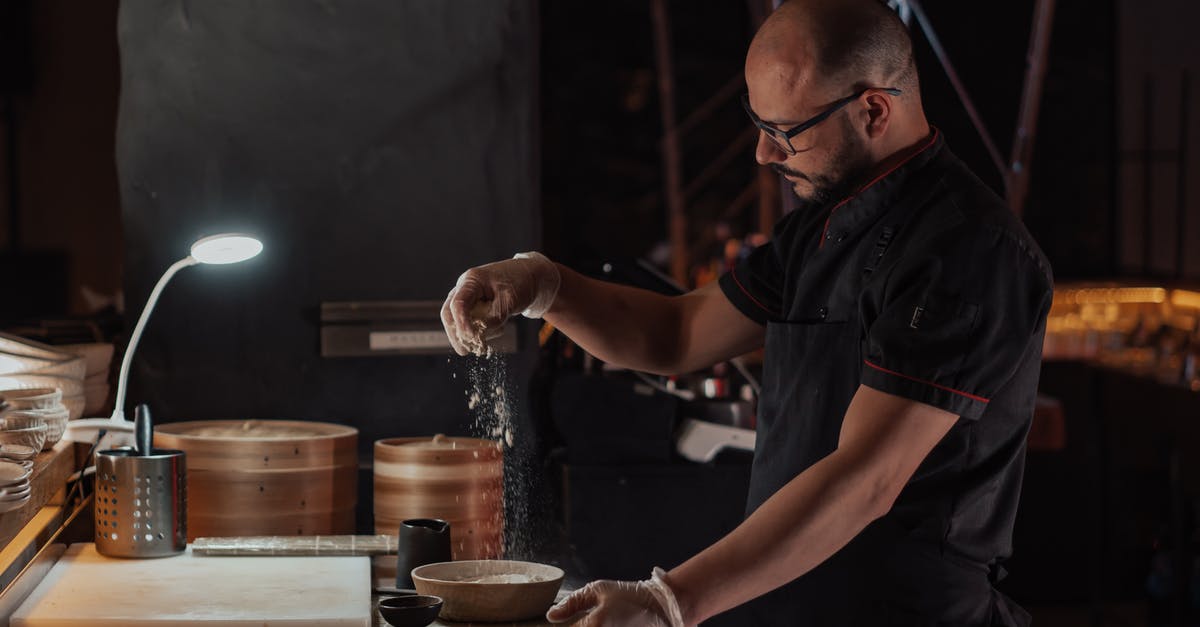Making Dumpling Conserve Better - Man in Black Chef Uniform Sprinkling Flour on Ceramic Bowl