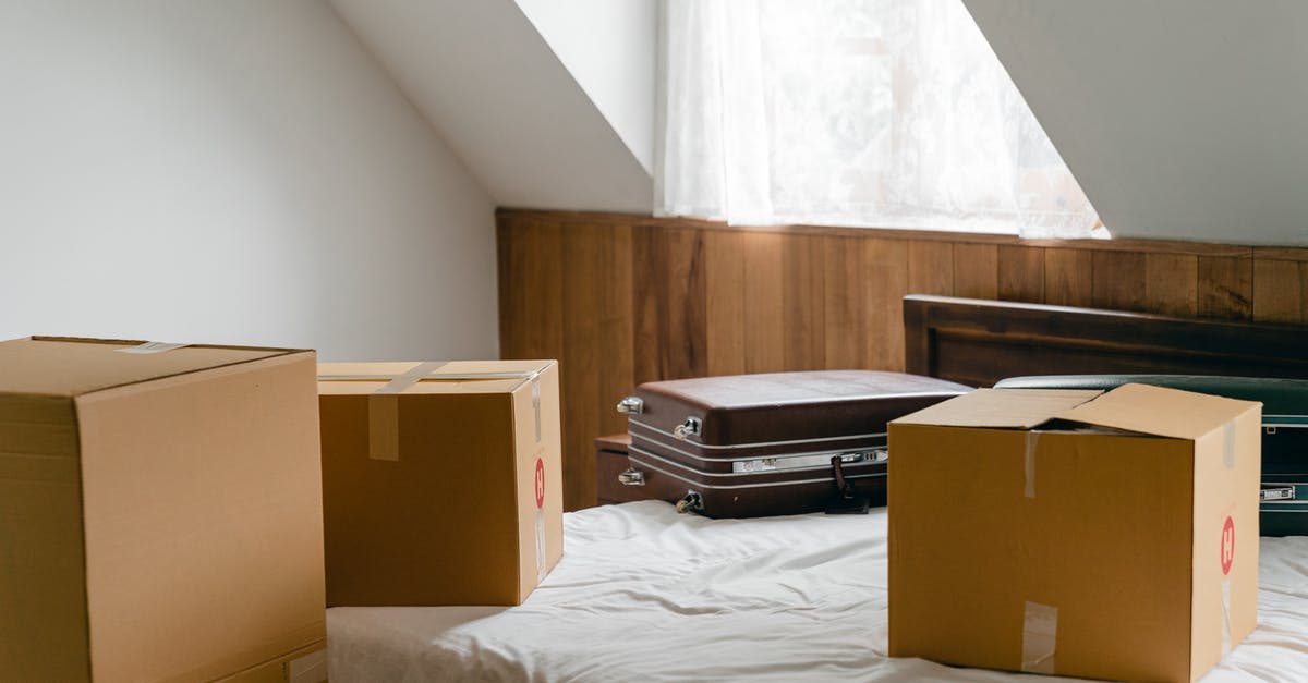 Making Herman the German starter using brown sugar - Small cardboard boxes and leather cases placed on bed with sheet near big box in light room of house under sloping roof