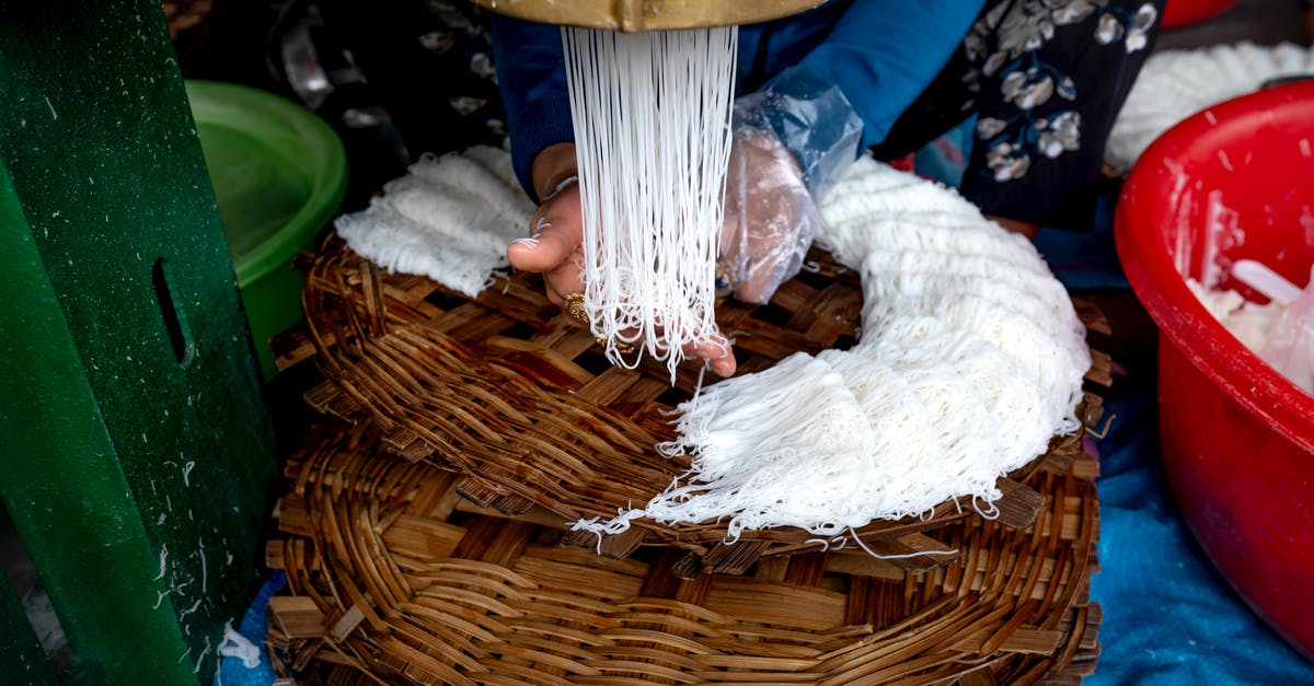 Making noodles in a wok - A Person Making Noodles