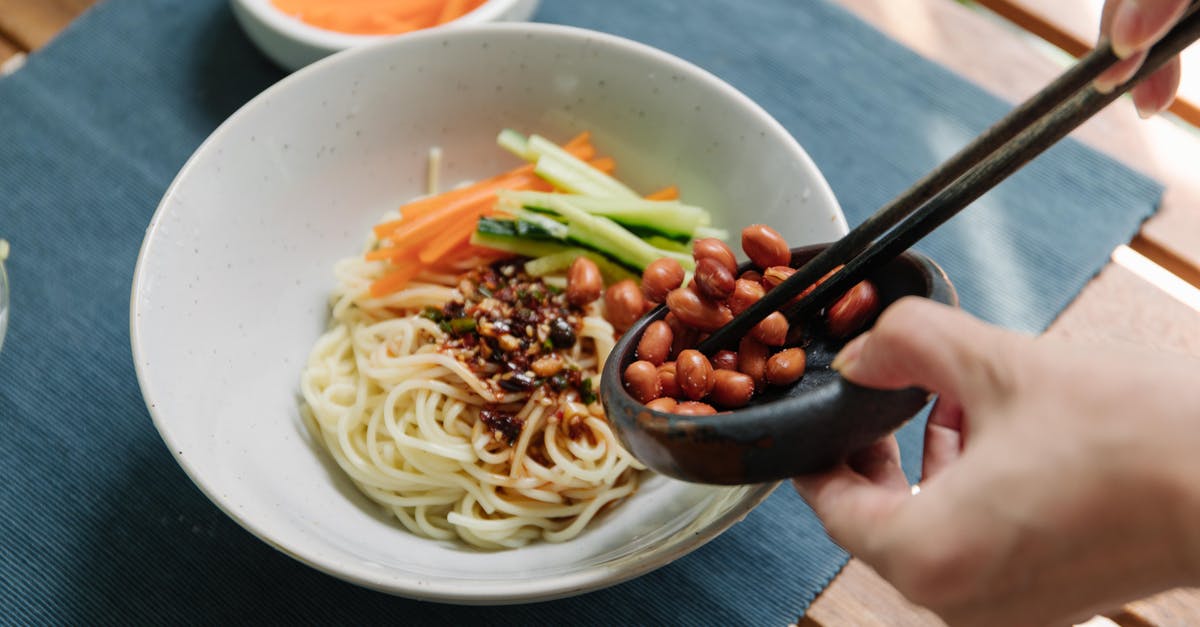 Making noodles in a wok - Person Making Food with Noodles, Vegetables and Nuts