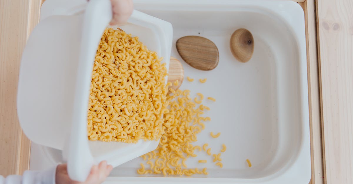 Making that little butter thing you put on top of steak - Unrecognizable crop kid adding raw pasta to white container