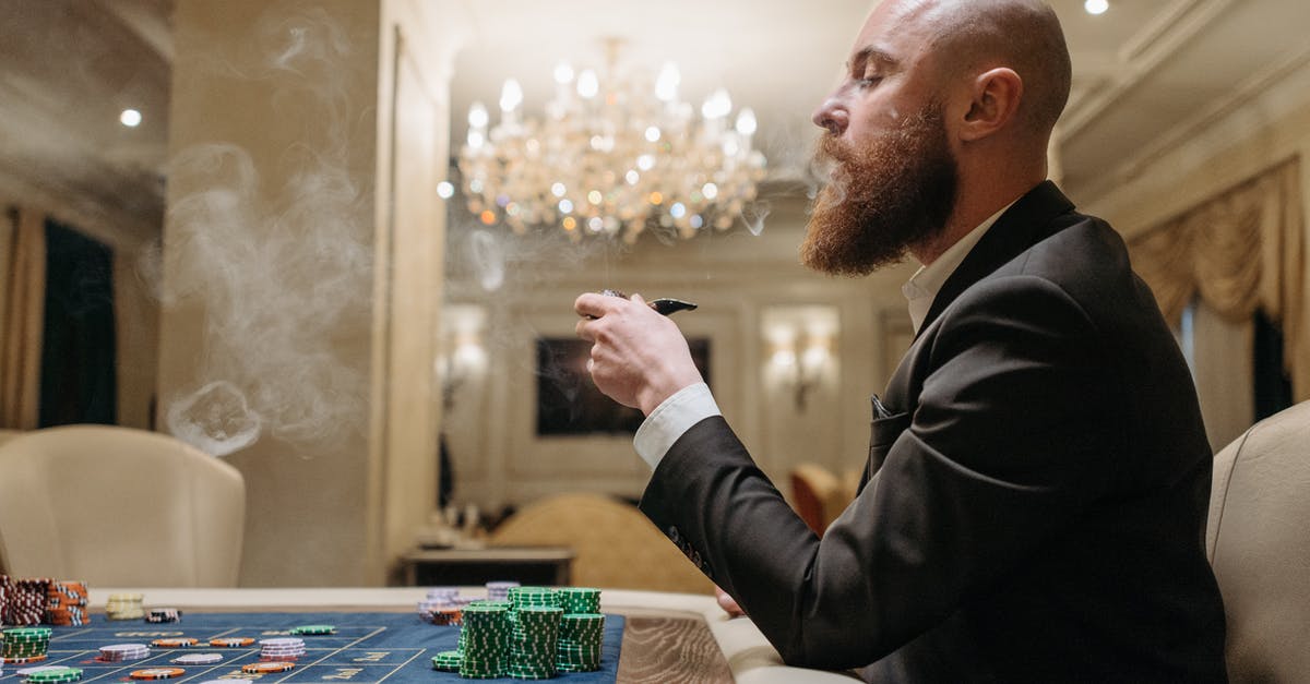 Marinade and Smoke Chips - Man in Black Suit Smoking Pipe While Playing on a Gaming Table