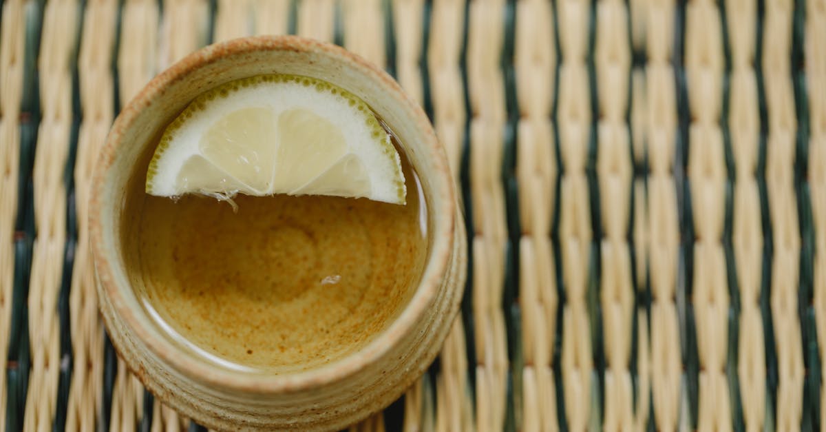 Masking the grass flavor of green tea - Oriental cup of green tea on straw mat