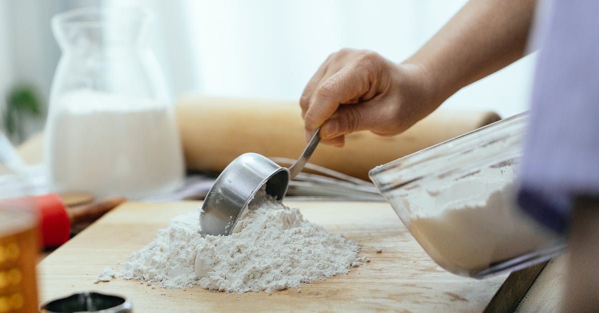 Mayonnaise substitute in cake batter - Crop adult woman adding flour on wooden cutting board