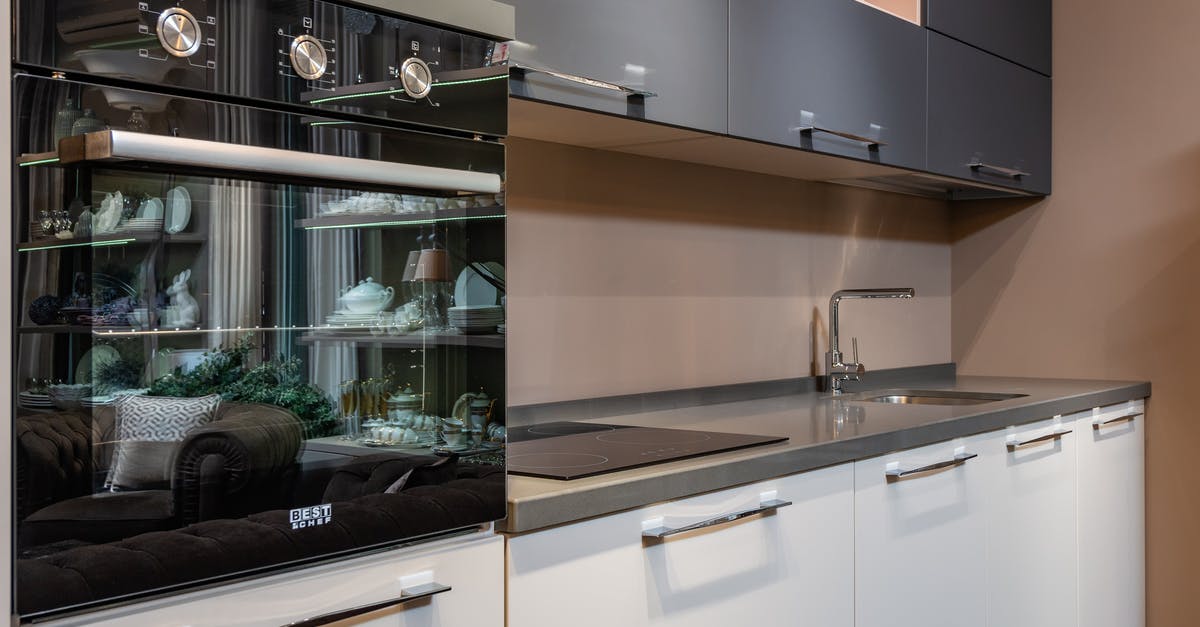 Measuring Oven Temperature: Surface or Air? - Modern black oven placed on counter with stove and sink in light stylish kitchen with white and gray cupboards in apartment