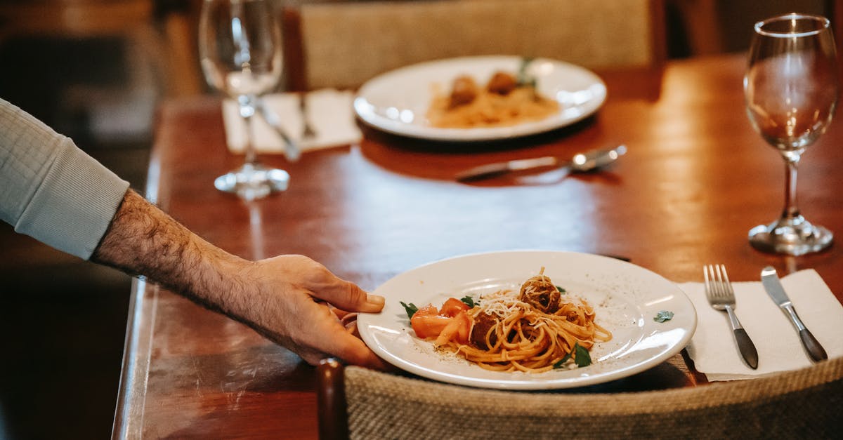 Meatballs and Spaghetti in the InstantPot separately - Unrecognizable waiter serving pasta on table with glasses in restaurant