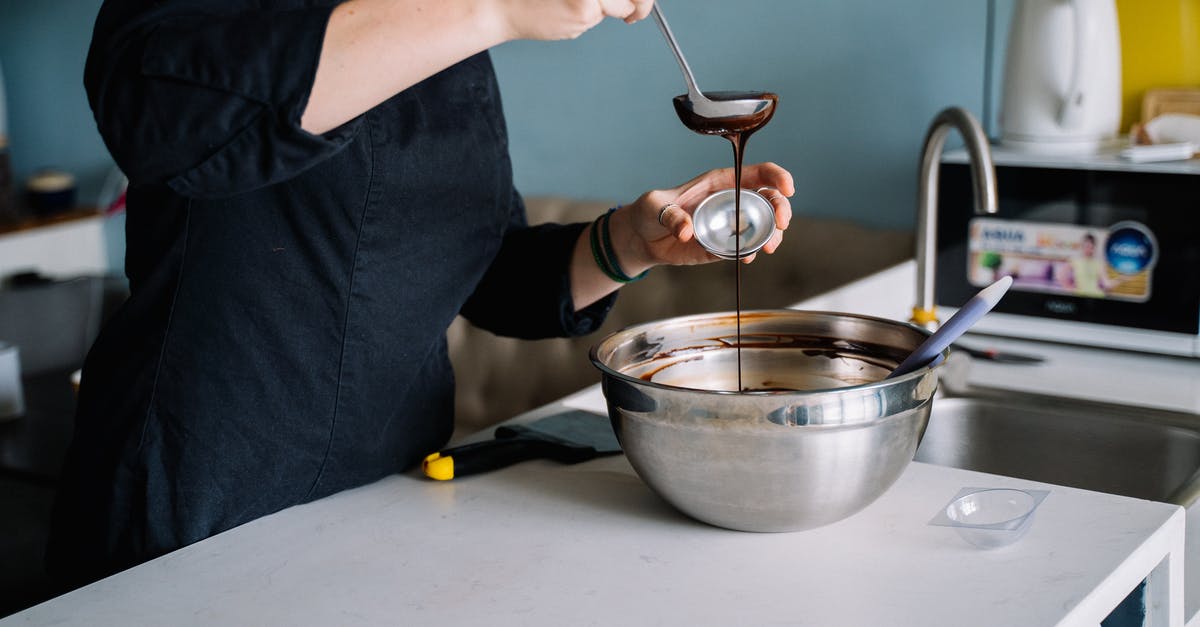 Melted chocolate wafers - Person in Blue Denim Jeans Holding Silver Spoon