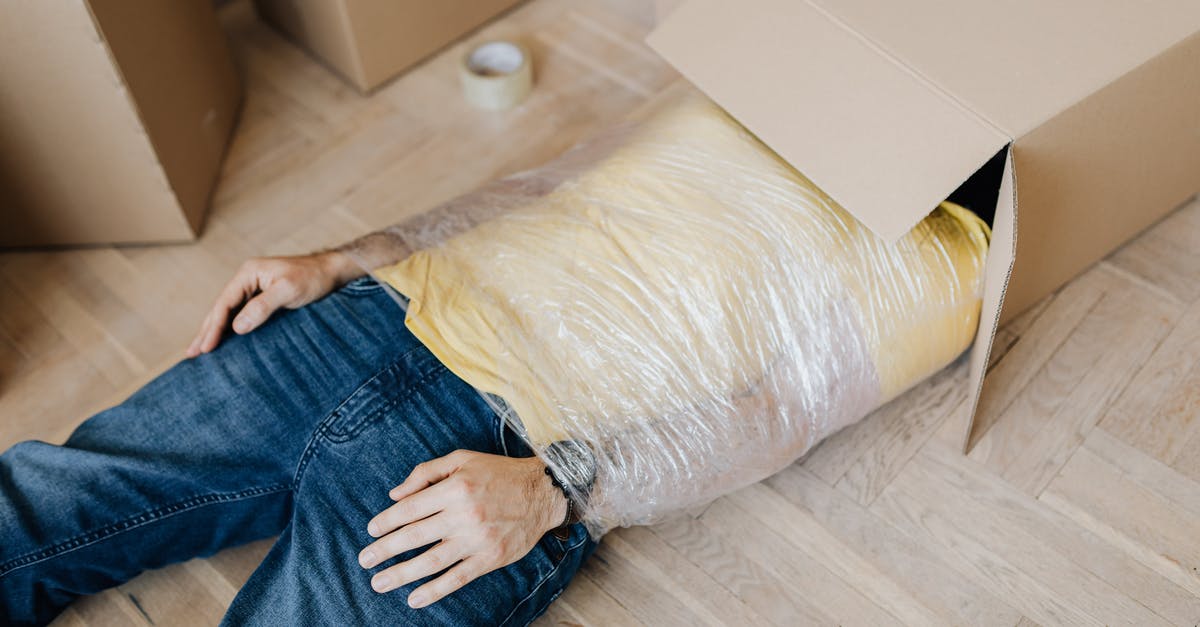 Melted plastic wrap in oven at high temp - Man tied up using tape with head in carton box