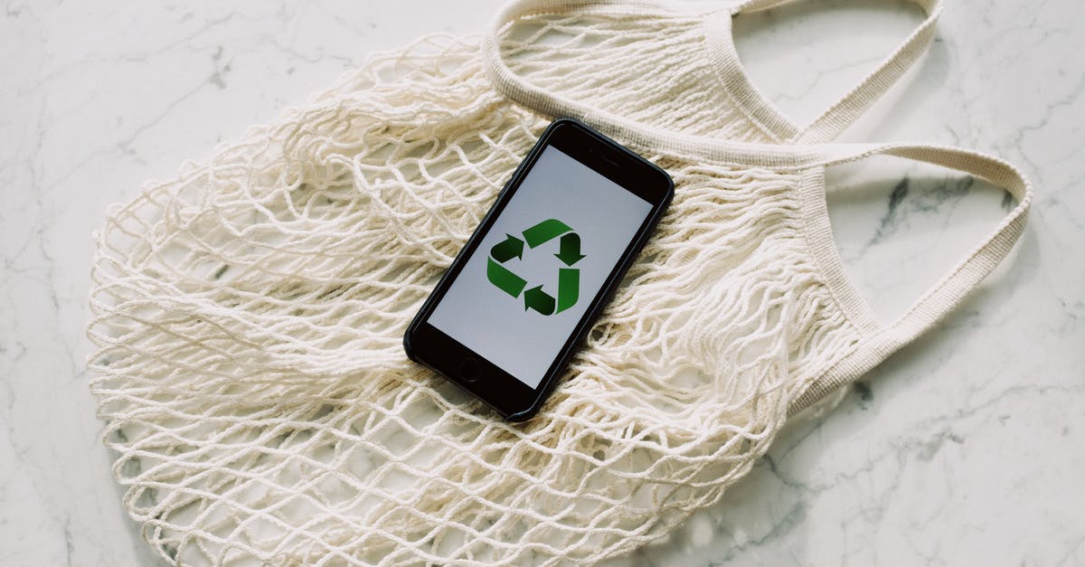 Mesh size for straining yogurt? - Overhead of smartphone with simple recycling sign on screen placed on white eco friendly mesh bag on marble table in room