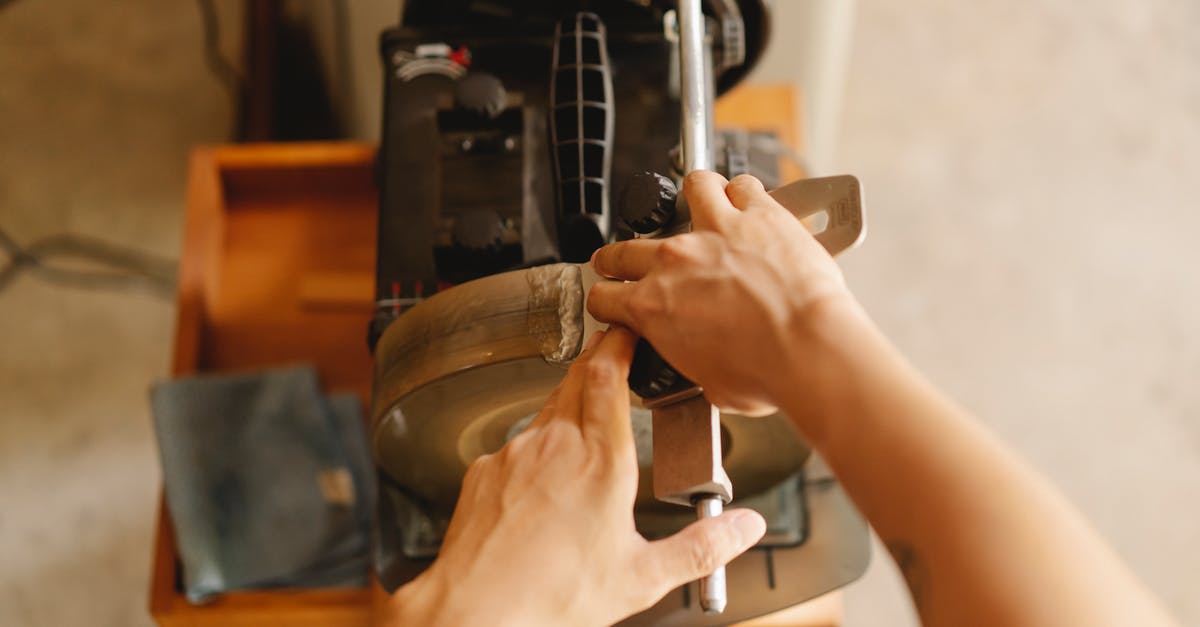 Method of sharpening knives with steel - Crop man working sharpening machine