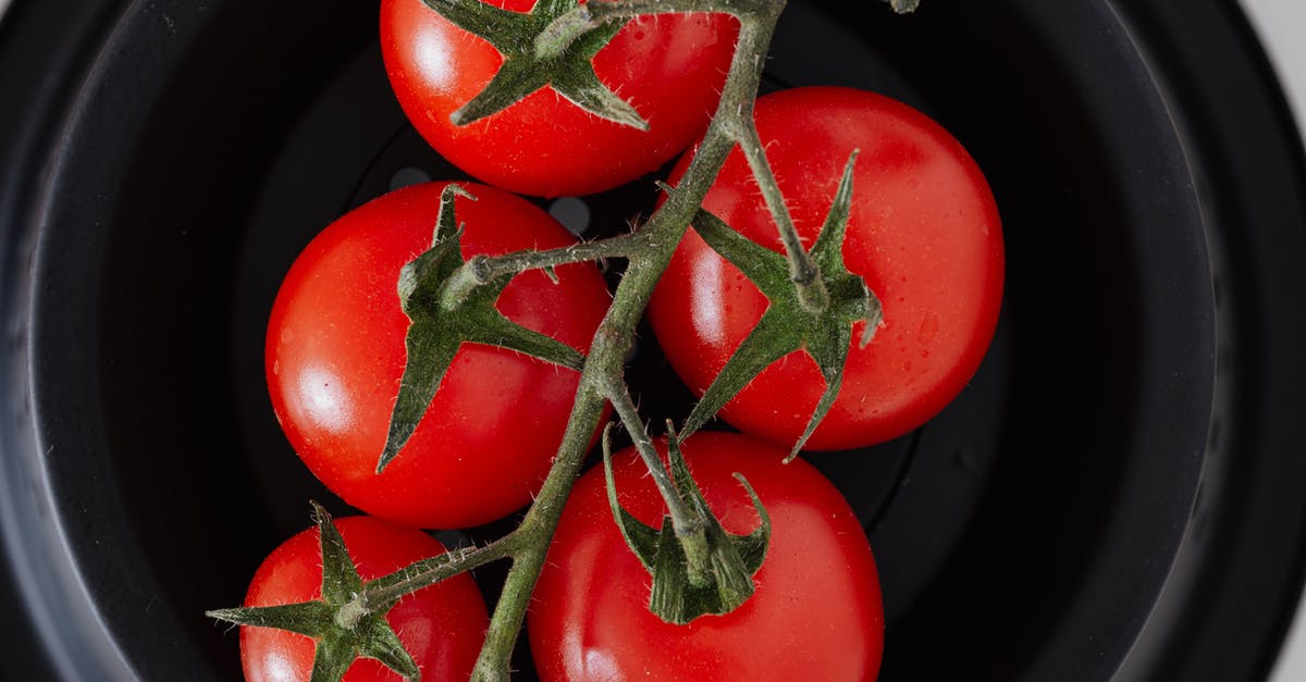 Microwave cooking time with porcelain/stoneware container rather than plastic - From above of fresh fragrant small tomatoes on branch placed in black bowl preparation for healthy breakfast at home