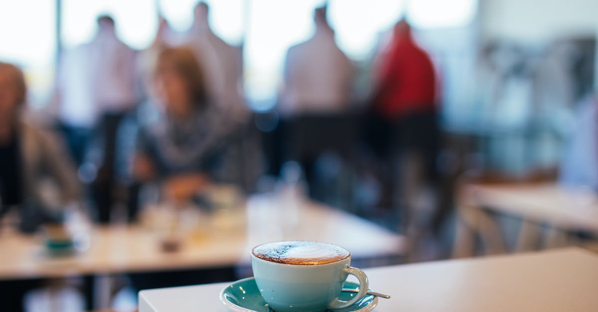 Milk seal didn't break - Cup of tasty coffee with froth in cafe with people