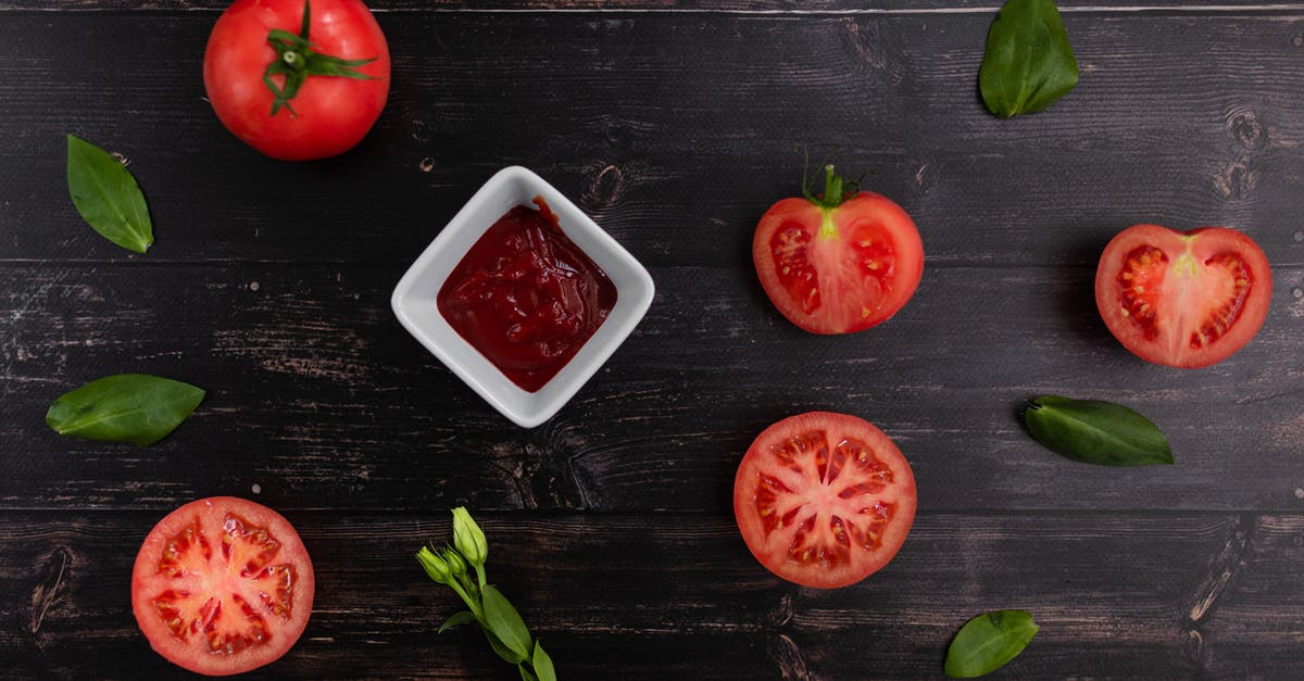 Missing ingredient from Peach Salsa can I recan - Top view of ceramic bowl with tomato sauce near bright ripe tomatoes and basil leaves on wooden table