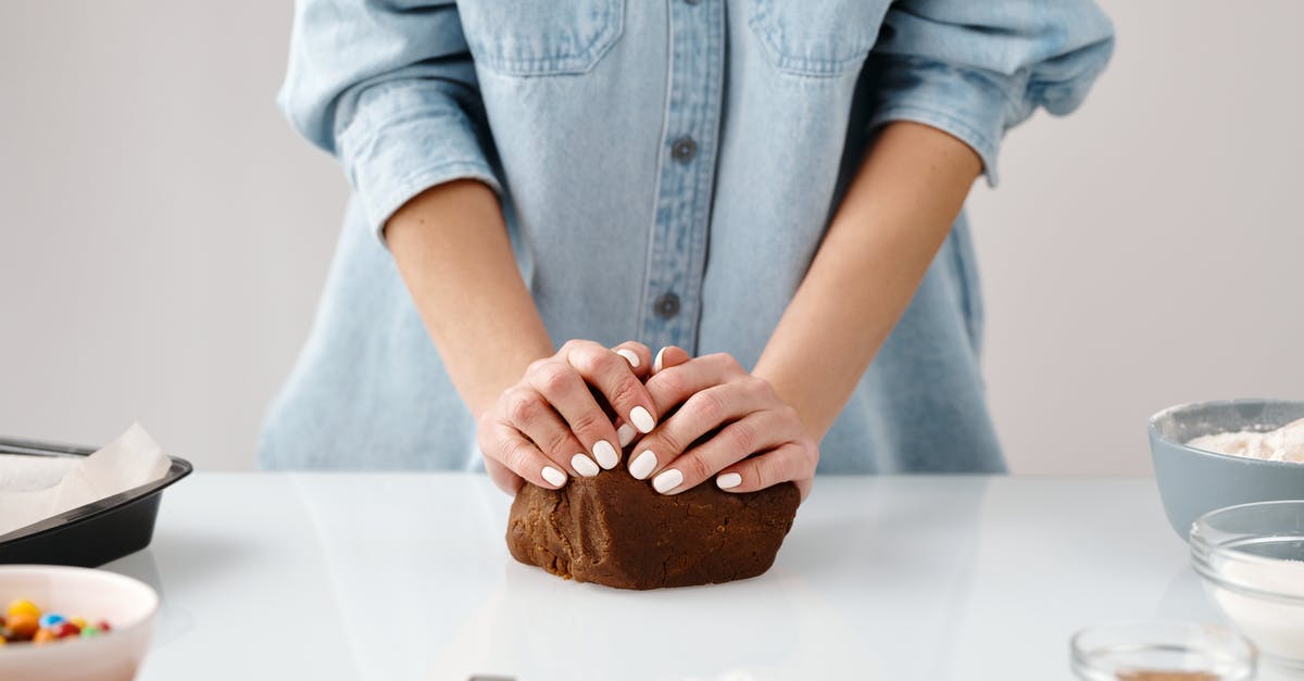 Mixing cooking chocolate with normal chocolate - Person Kneading a Chocolate Dough by Hands