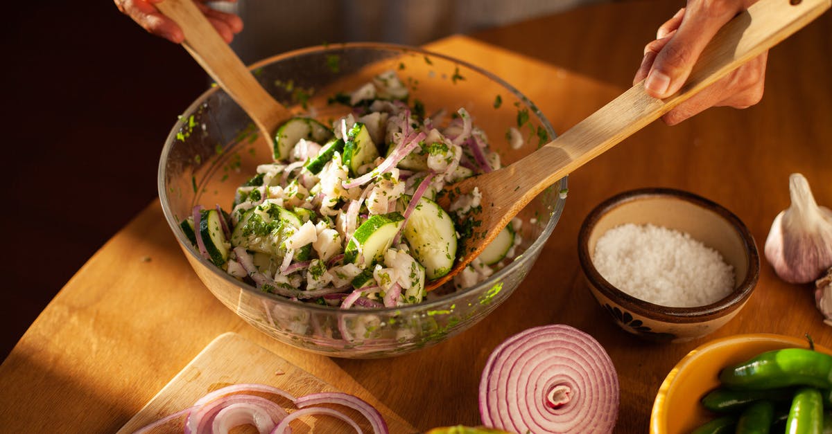 Mixing Ghee with Other Ingredients - A Person Mixing Salad using Wooden Spoons