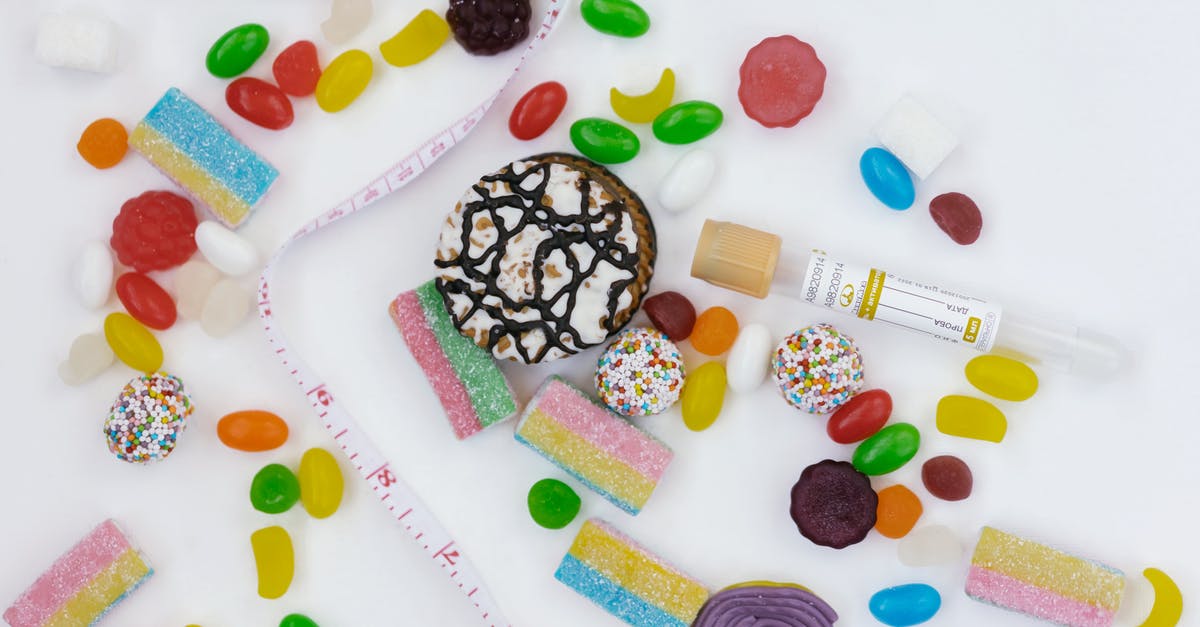 Mixing starches with sugar to make chewy candies - A Tape Measure on a Table Surrounded with Assorted Chewy Candies and Cookies 