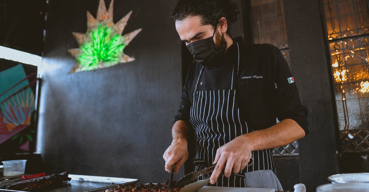 Modernist Cuisine-style BBQ brisket safety - A Man in Black Long Sleeves Wearing Face Mask while Slicing a Steak