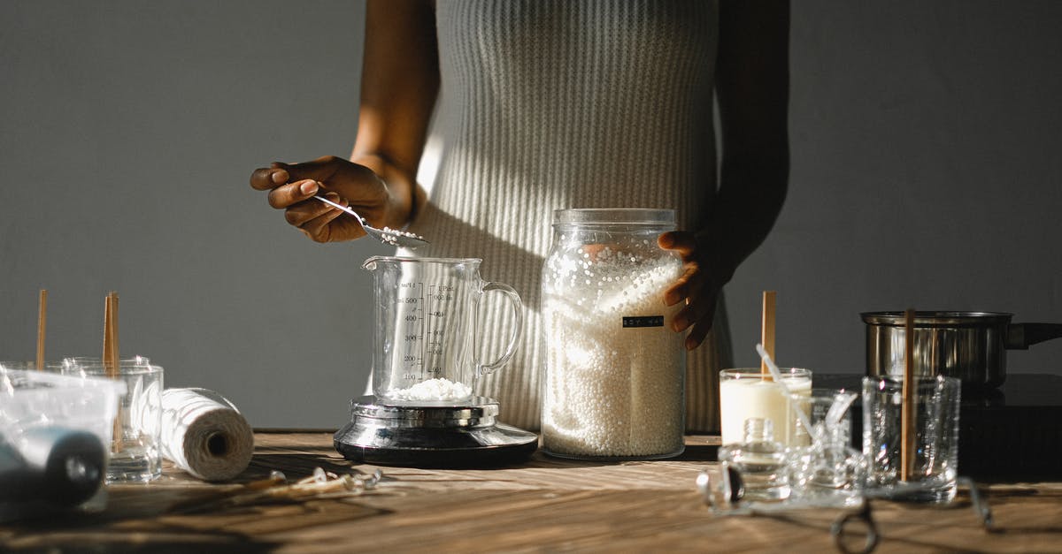 Mold on homemade sriracha - Crop black woman pouring wax into beaker