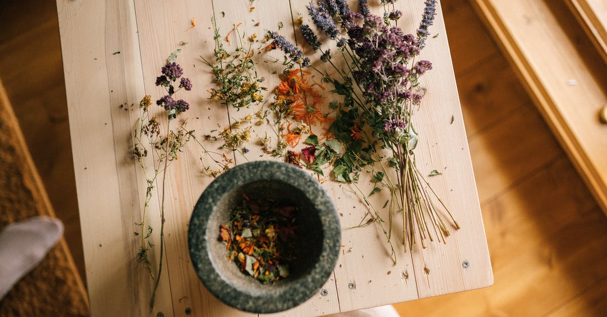 Mortar and Pestle: Granite vs Porcelain - Dried Flowers over a Wooden Table