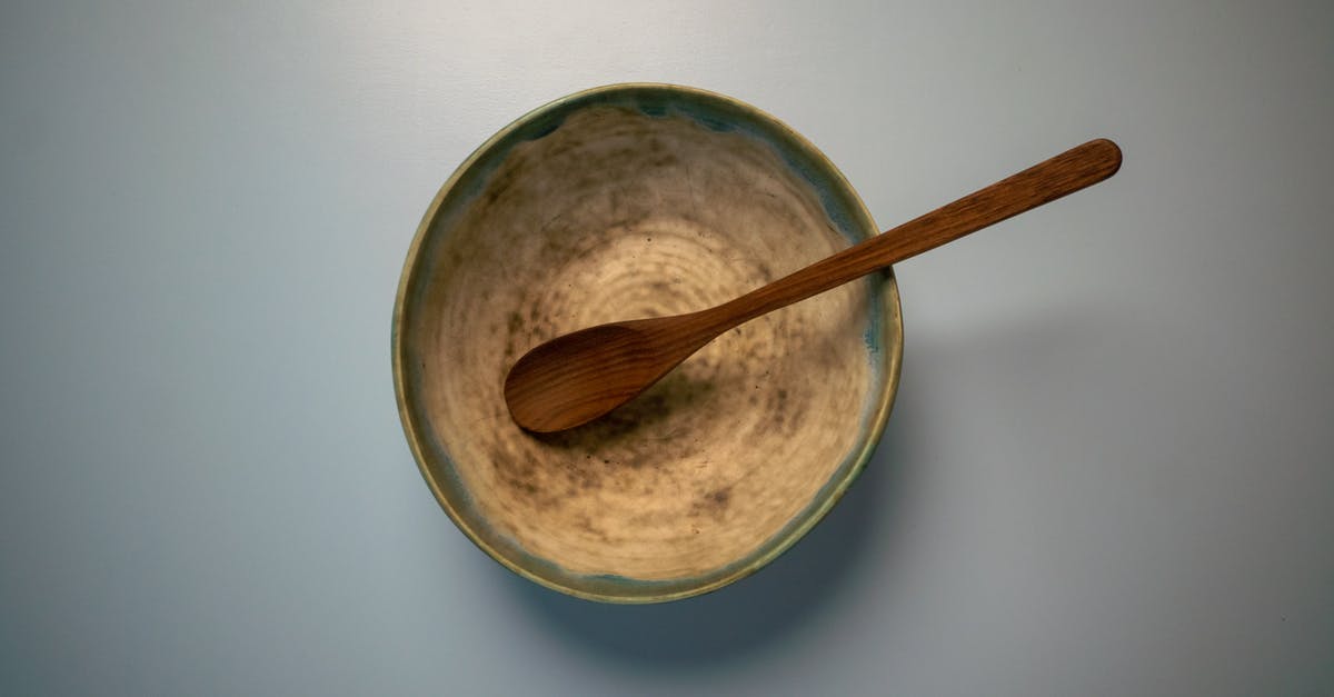 Mould on top and bottom of white wine vinegar - Bowl with wooden spoon on white table