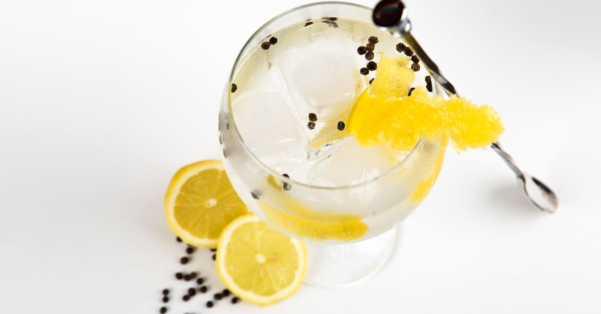 Mould on top and bottom of white wine vinegar - Liquor With Ice Cubes and Slice of Yellow Fruit