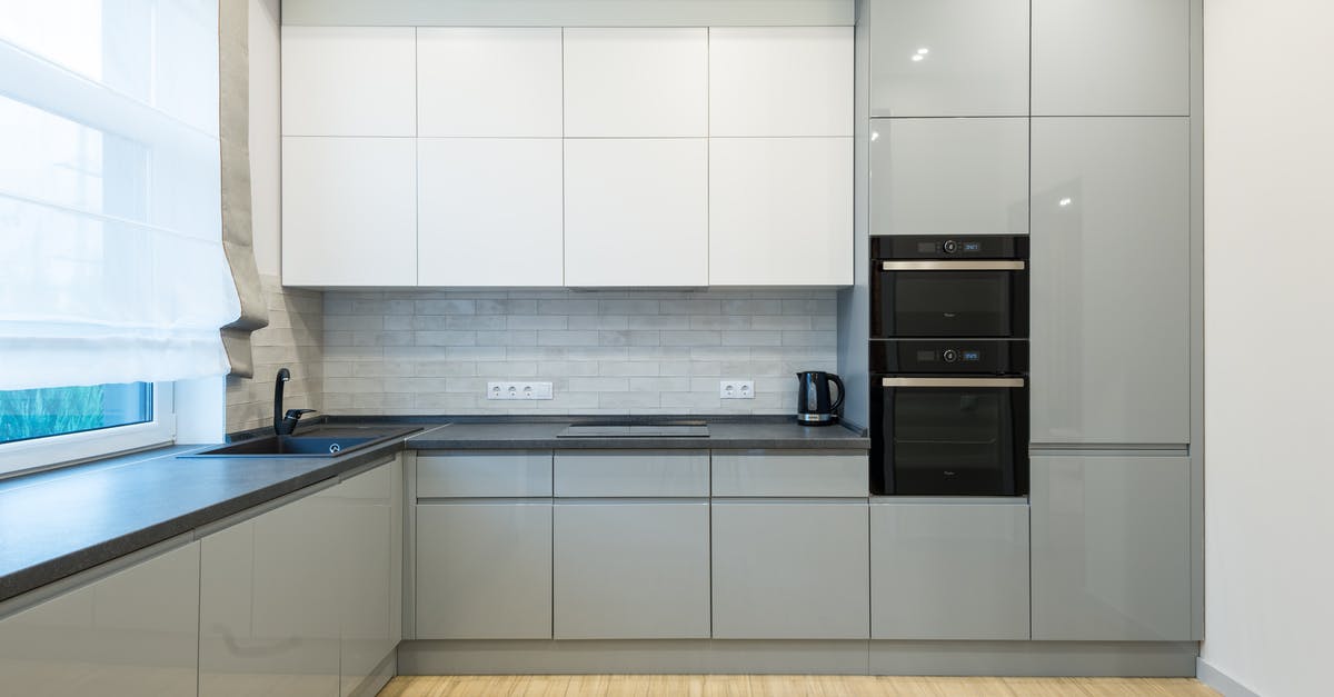 Multi cooker - with pressure cooker versus without - Interior of contemporary kitchen with gray and white cabinets with sink and modern oven near electric cooker in spacious apartment