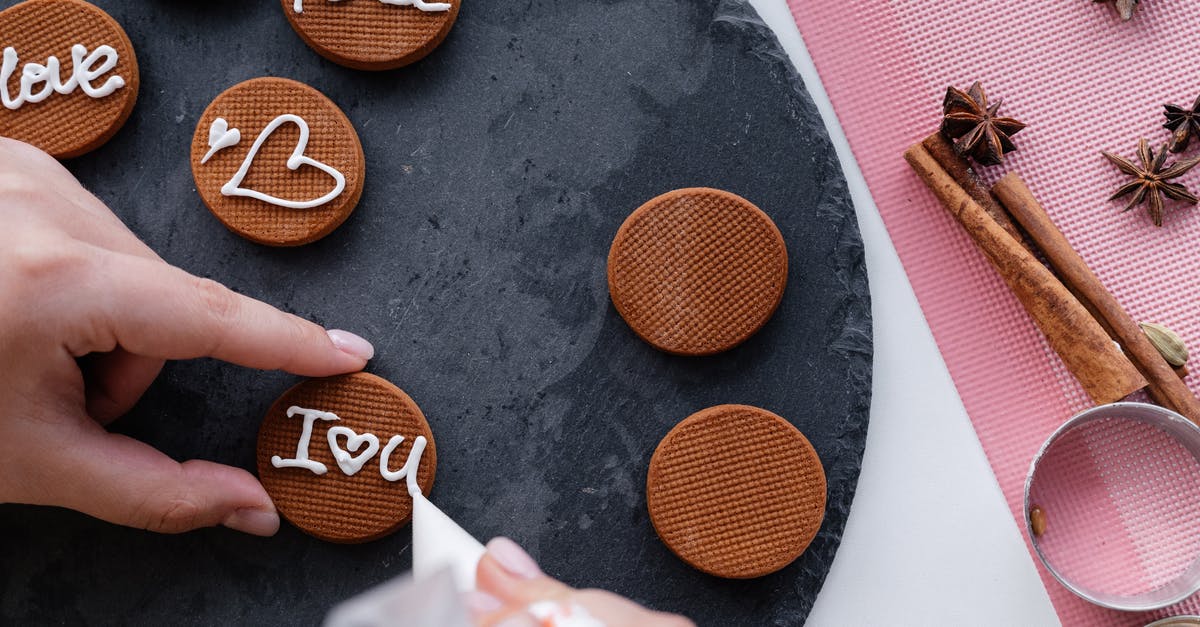 Multi-nozzle piping rig? - Crop woman decorating delicious cinnamon cookies with icing