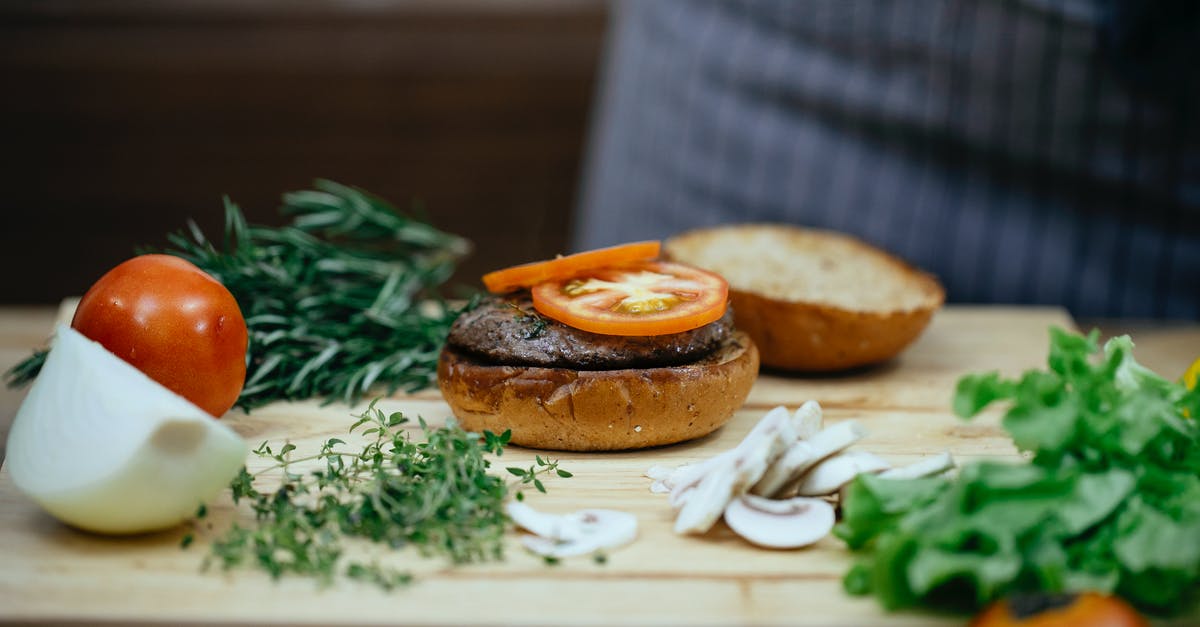 Mushroom replacement in Beef Wellington - Crop cook at table with tomato on bun