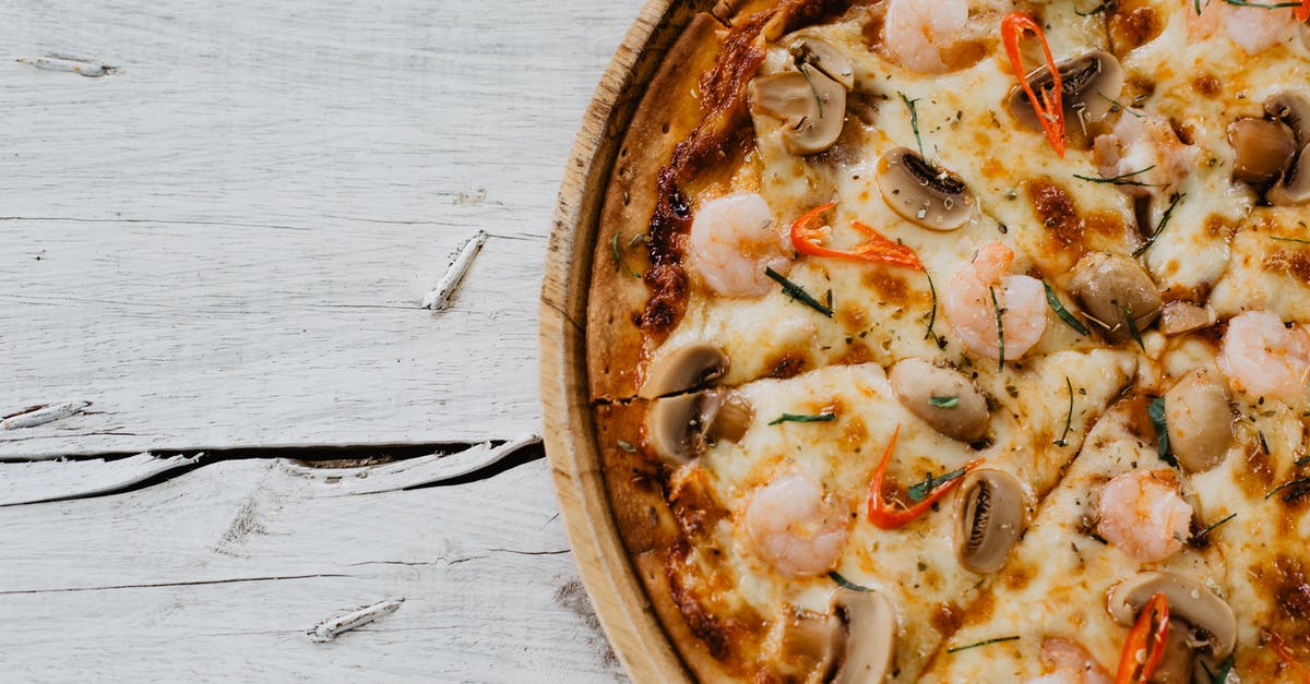 Mushroom soy sauce, brand identification or substitution - Appetizing pizza with shrimps and champignon on wooden table