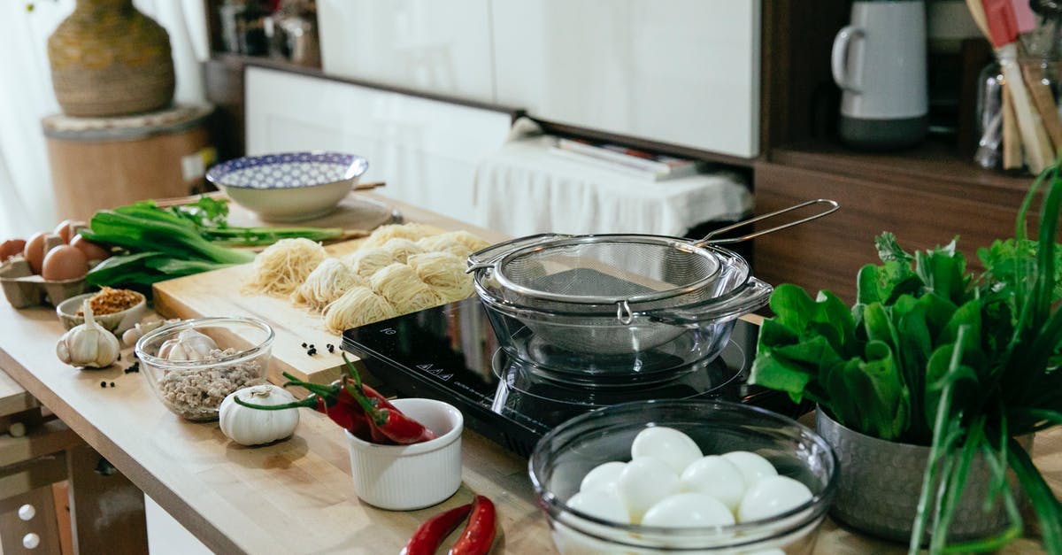 Mushy homemade dill pickle chips - Table with spices chopping board with noodles and bowls in kitchen