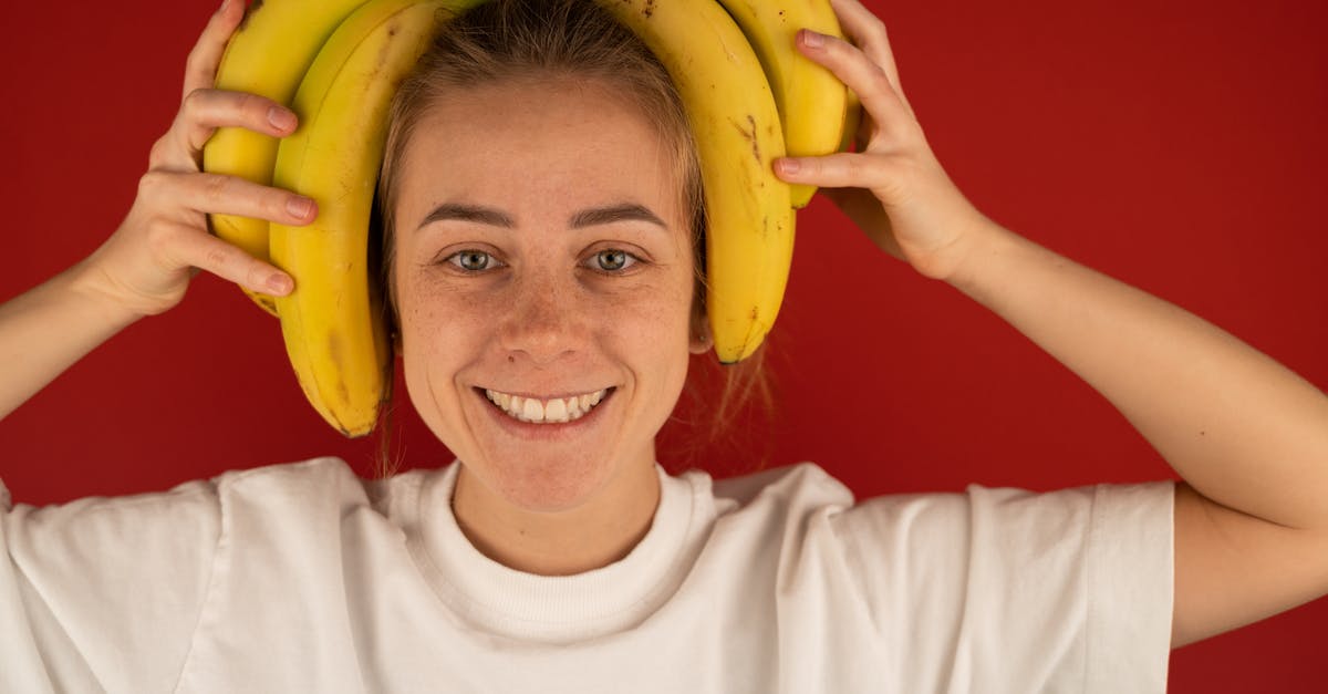 My banana Muffins won't rise like I want - Why? - Smiling woman with bunch of fresh bananas on head