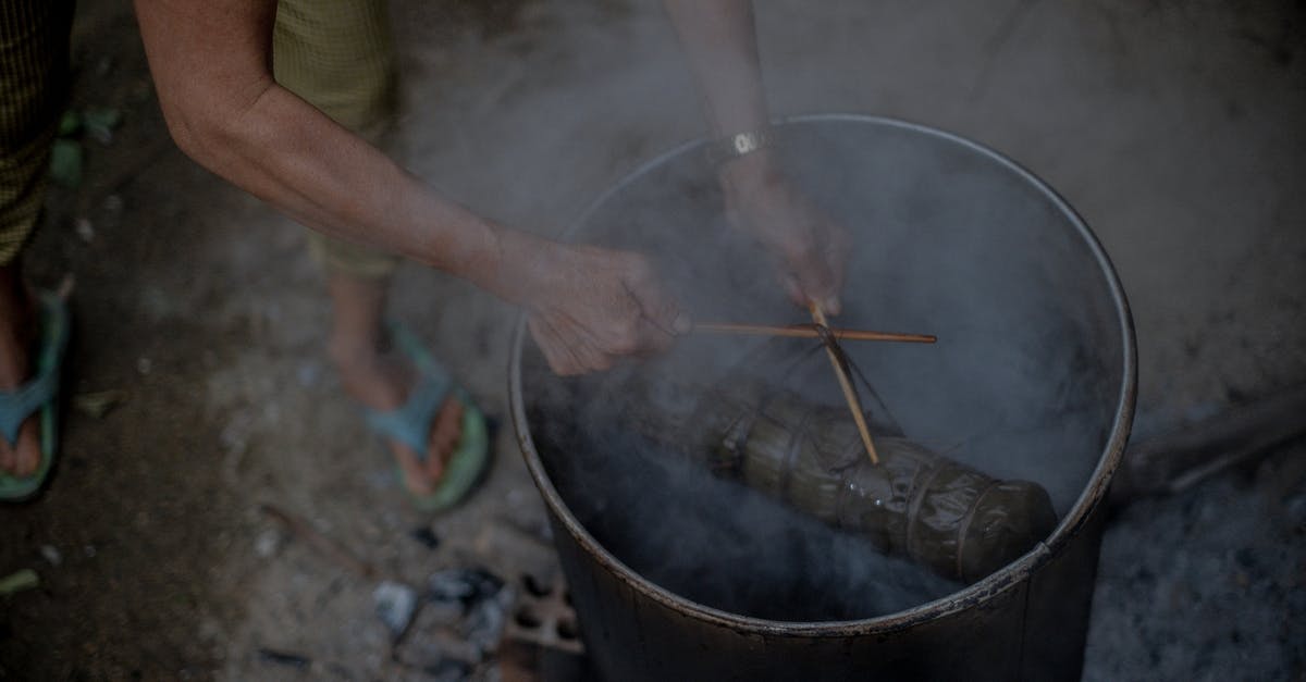 My cooking pot keeps smoking - A Person Cooking on a Black Pot