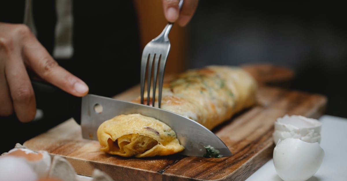 My egg roll wraps smell sour. They expire in 2 days. Are they still okay to use? - Crop anonymous cook with knife and fork cutting yummy hot egg roll on wooden board