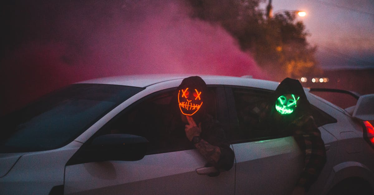 My seitan is horrible - Unrecognizable men in glowing Halloween masks driving car at night