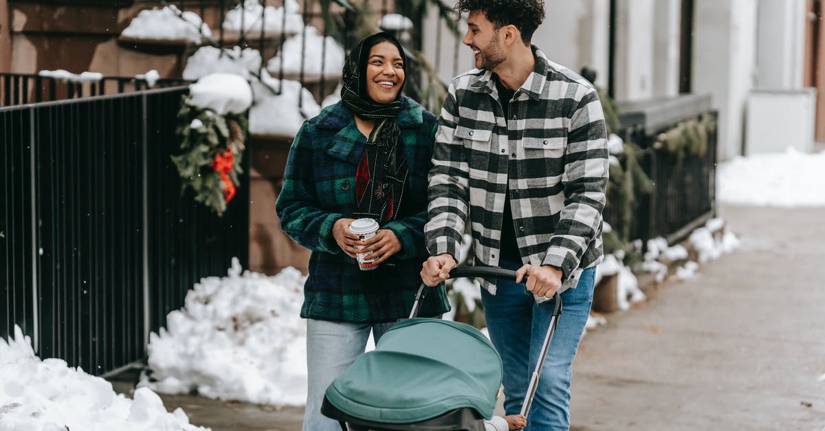 My sourdough starter is going wrong in every possible way - Happy ethnic couple walking with stroller on street in residential city district