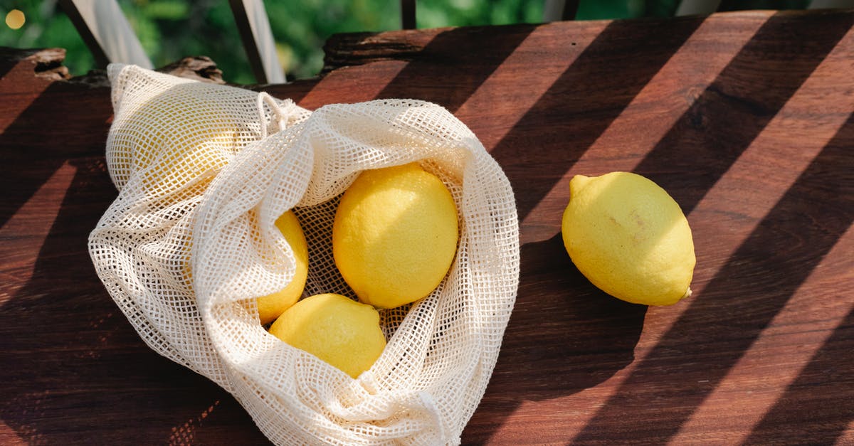 Mysterious bitter taste from tropical fruits and coconut - Lemons in bag on wooden surface