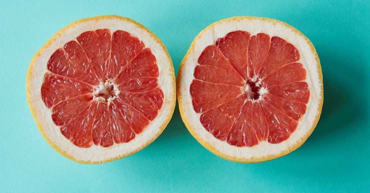 Mysterious bitter taste from tropical fruits and coconut - Ripe sliced grapefruit placed on blue surface