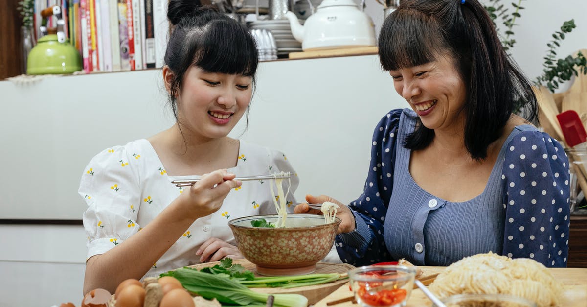 Mysterious Disintegrating Udon noodles - Joyful Asian women eating traditional noodles soup together