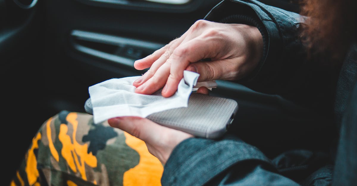 Need to remove germ from garlic or onion? - Crop person wiping smartphone with napkin