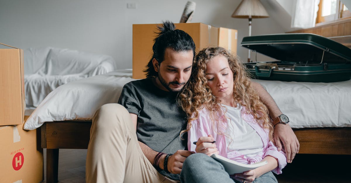 New corned beef ideas [closed] - Thoughtful male and female in casual wear sitting near bed among boxes together and taking notes while moving house