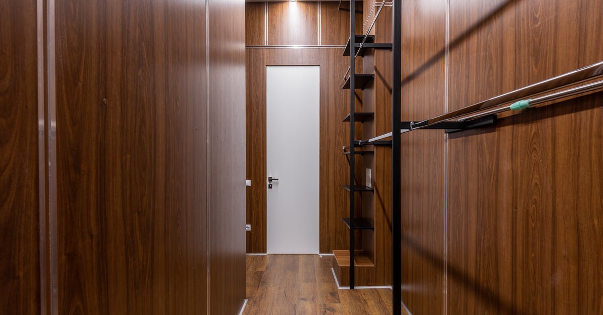 New lodge cast iron pan brown colour - Empty black shelves and racks placed near brown walls in corridor with minimalist style with white door and glowing illumination