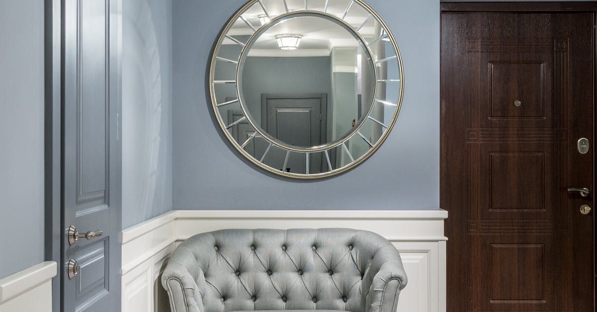 New takes on recipe format - Gray leather armchair placed under stylish round mirror in light corridor with gray walls in contemporary apartment in daytime