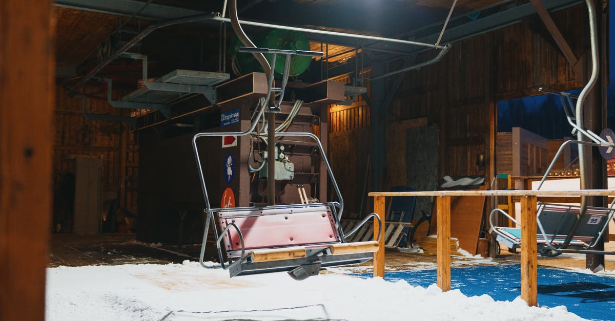 non stick presto electric skillet - Chairlifts on ropeways over snow with shadow in station with shiny light and wooden fence at dusk